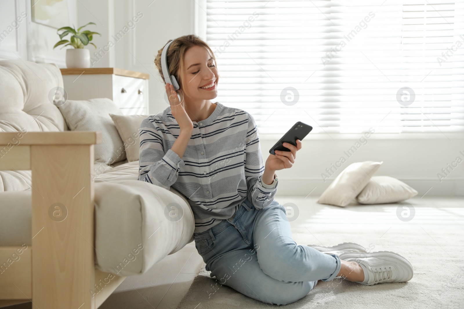 Photo of Young woman listening to music at home