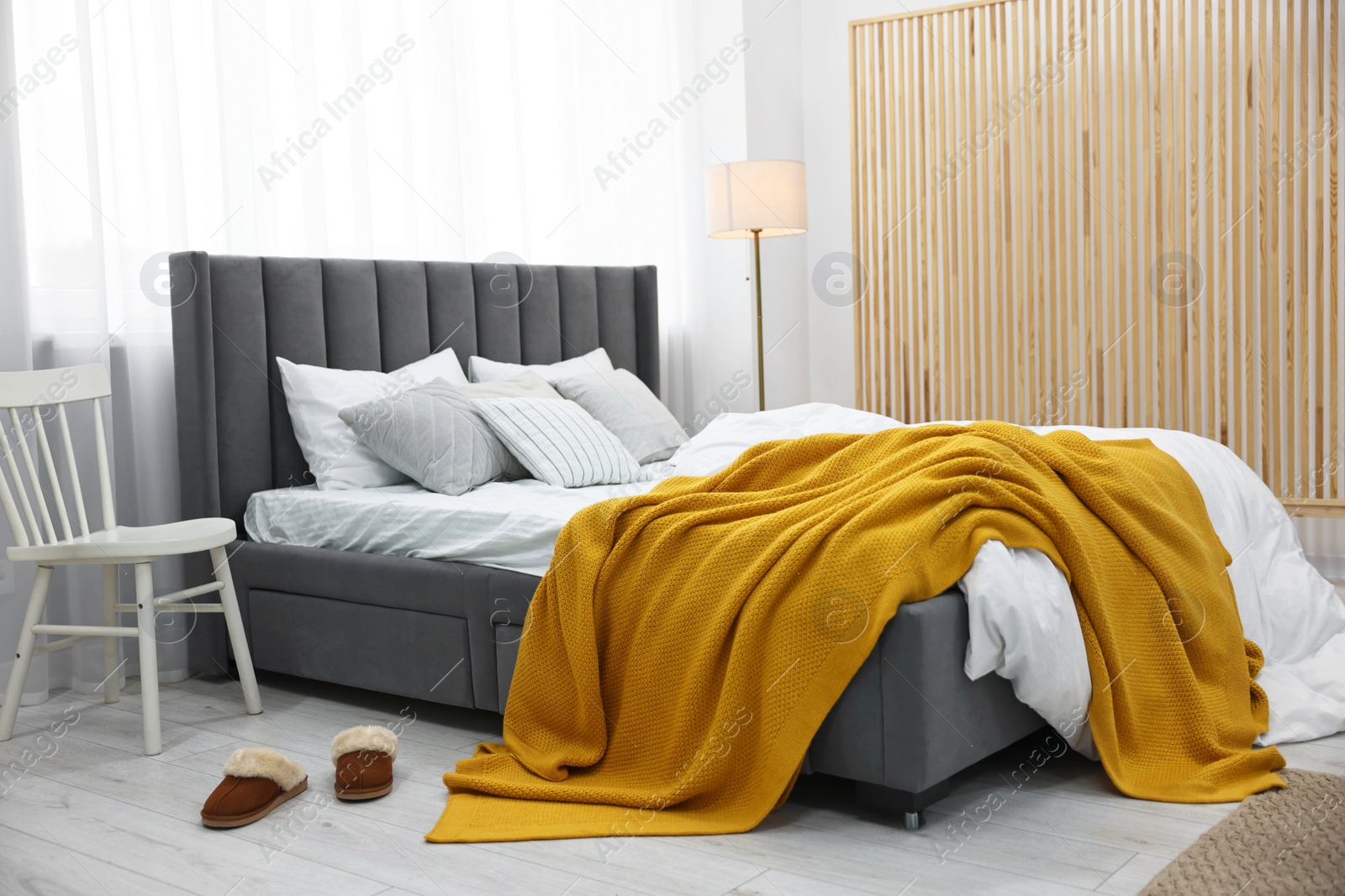 Photo of Bright plaid on bed in stylish bedroom