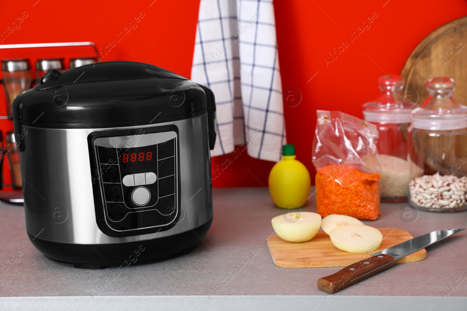 Photo of New modern multi cooker and products on table in kitchen