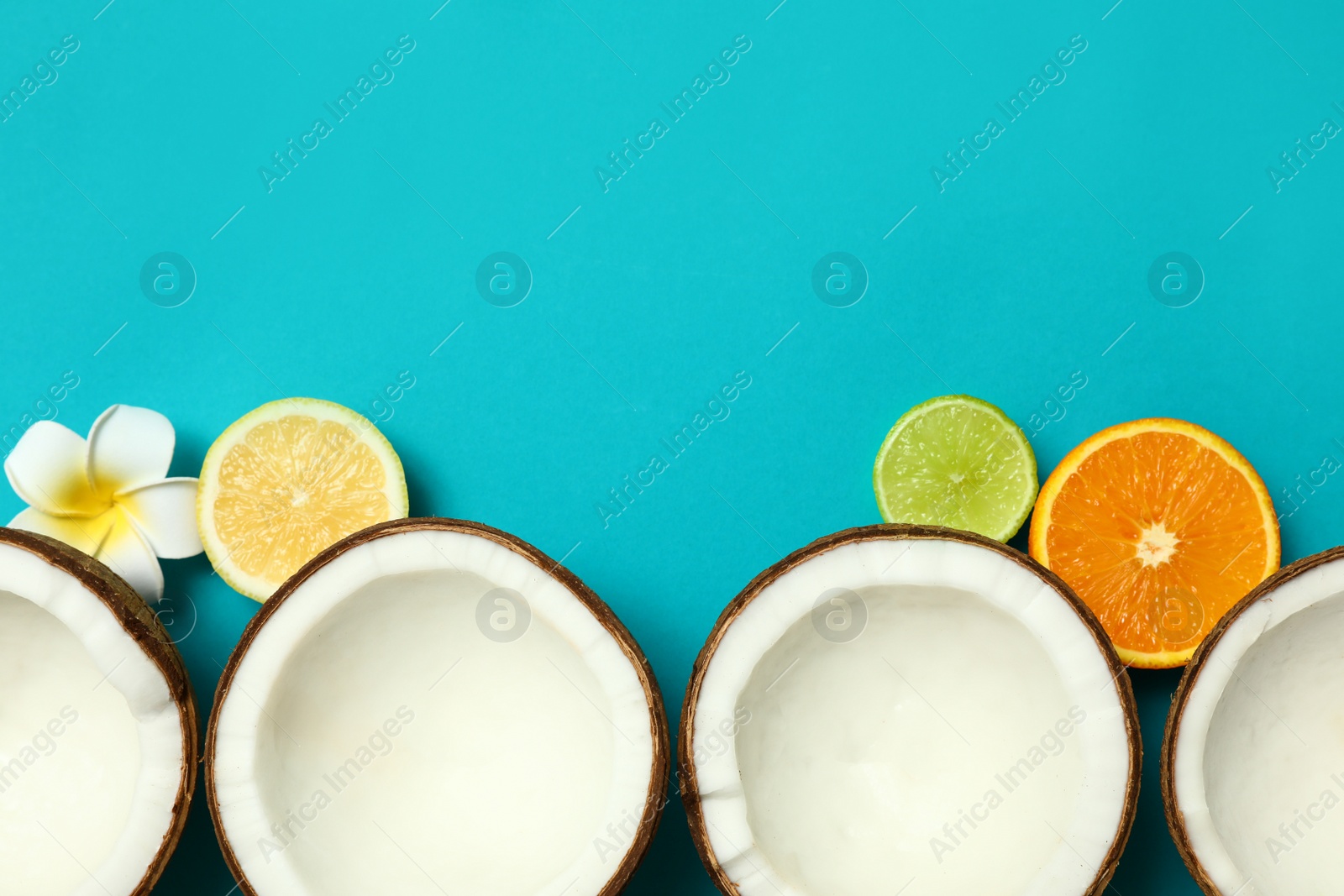 Photo of Flat lay composition with fresh coconut halves on blue background. Space for text