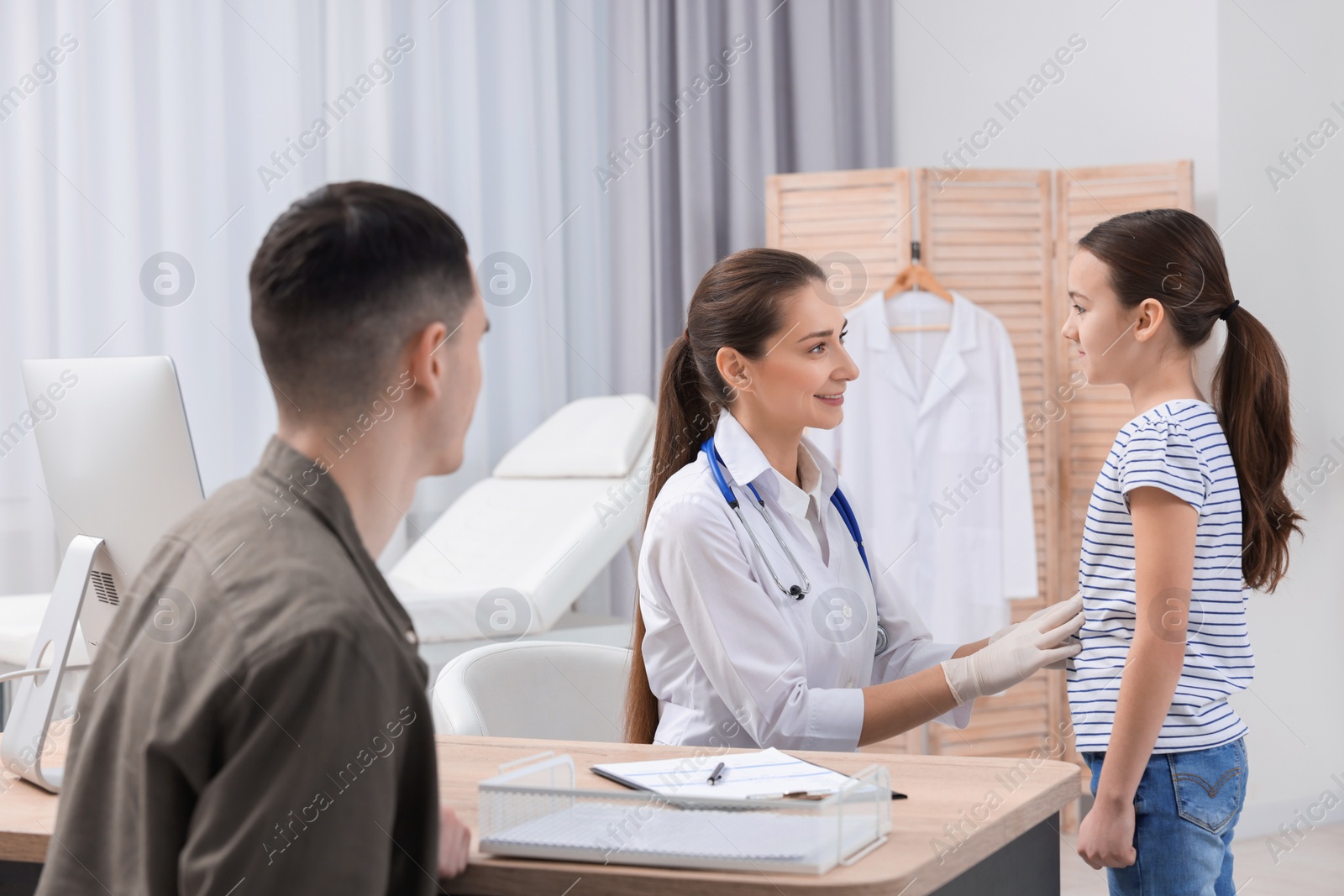 Photo of Gastroenterologist examining girl with stomach ache in clinic