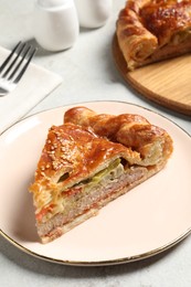 Photo of Piece of tasty homemade pie with filling on light grey table