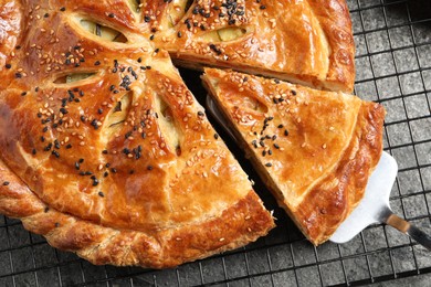 Photo of Taking piece of delicious homemade pie and server on grey table, top view