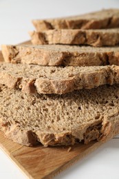 Photo of Freshly baked cut sourdough bread on white wooden table, closeup