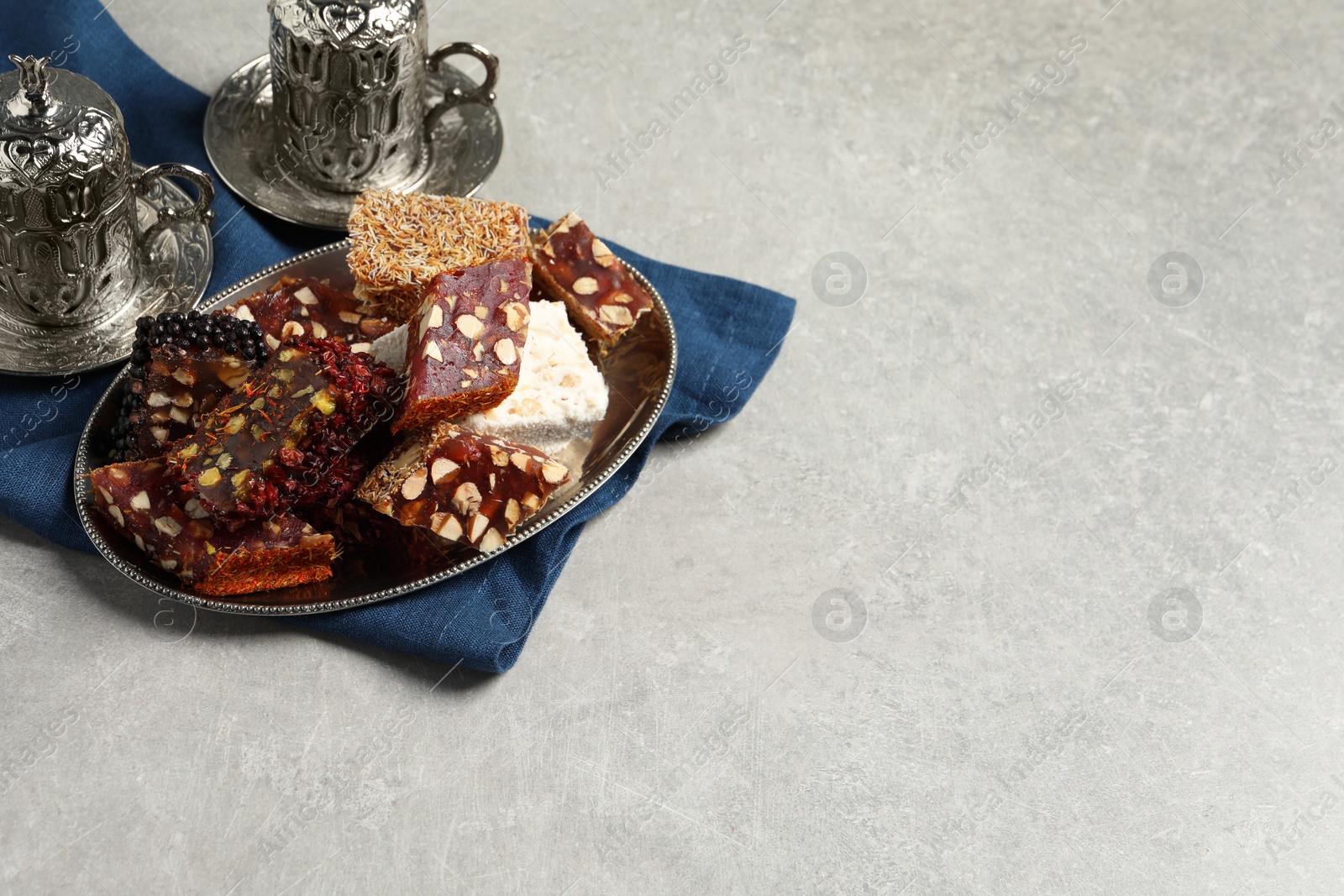 Photo of Tea and Turkish delight served in vintage tea set on grey table, space for text