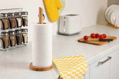 Roll of paper towels on white countertop in kitchen, space for text