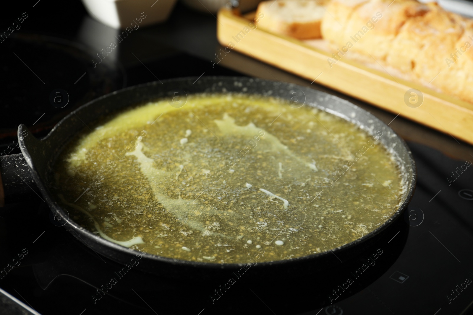 Photo of Melted butter in frying pan on cooktop, closeup