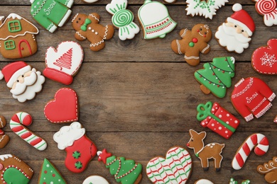 Photo of Frame of different Christmas cookies on wooden table, flat lay. Space for text