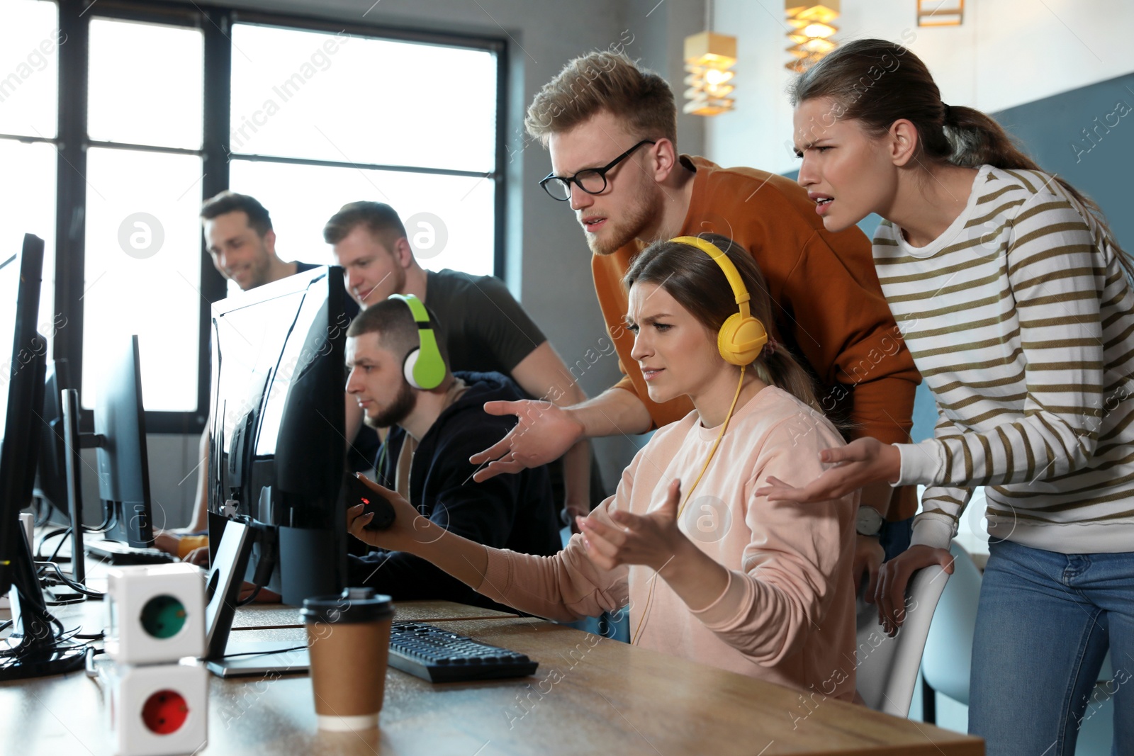 Photo of Group of people playing video games in internet cafe