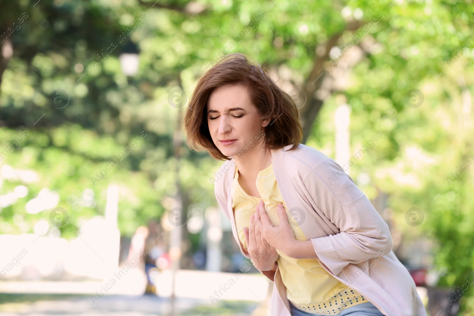 Photo of Mature woman having heart attack, outdoors