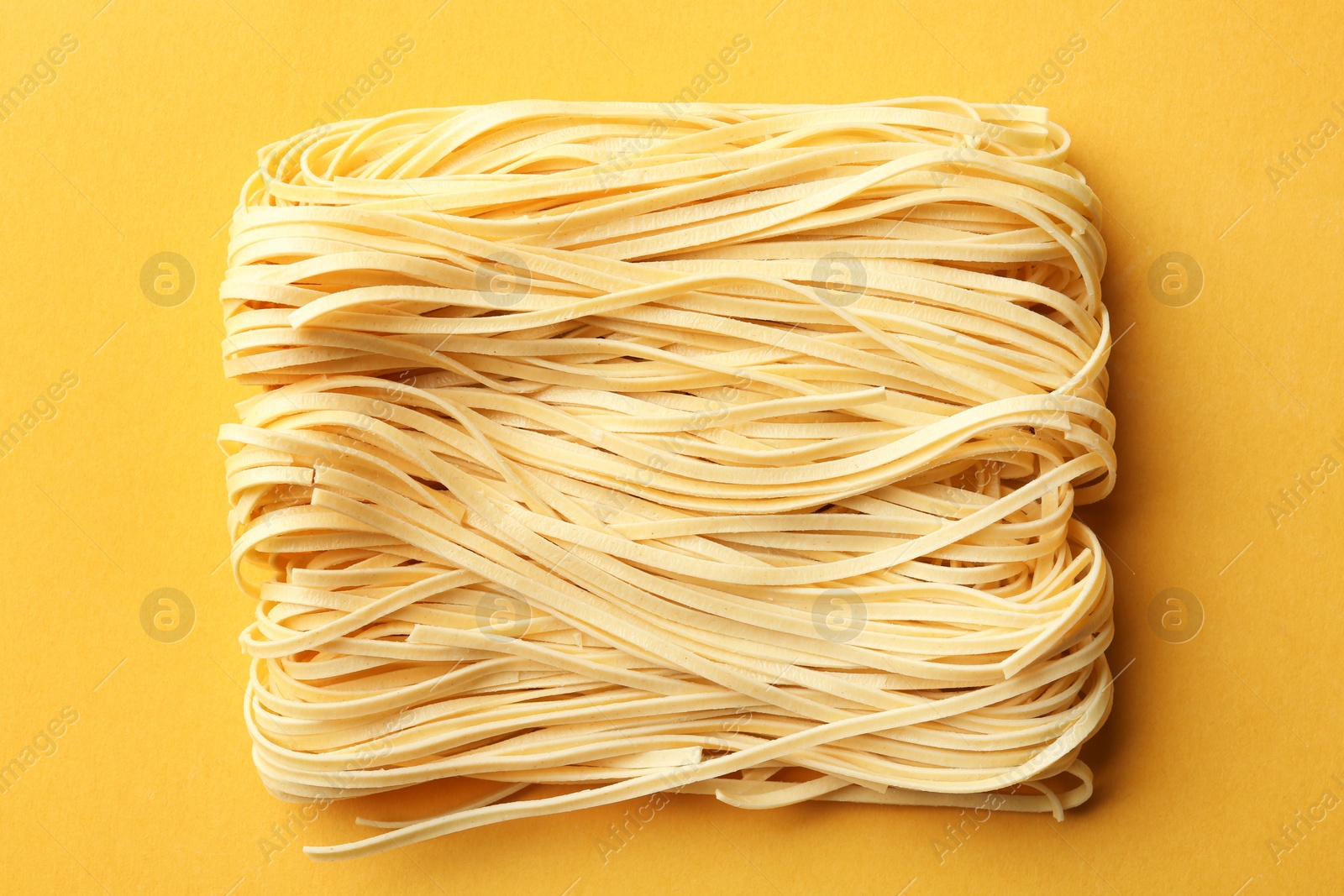 Photo of Block of quick cooking noodles on color background, top view