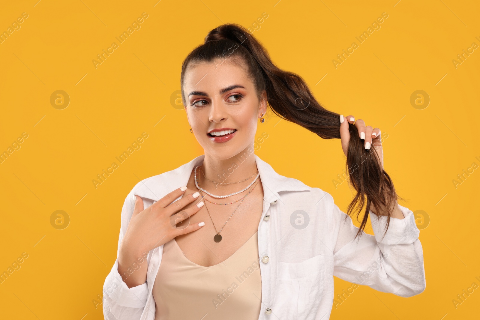 Photo of Beautiful woman with elegant jewelry on orange background