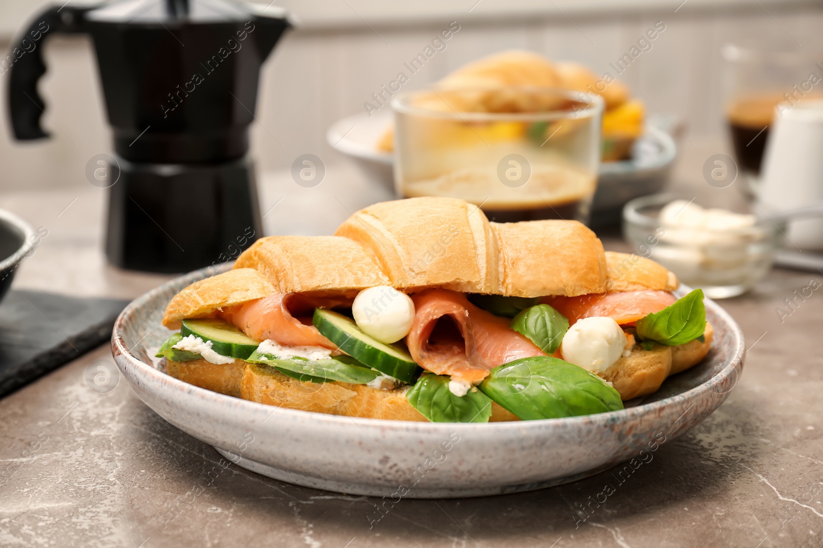 Photo of Plate with tasty croissant sandwich on table