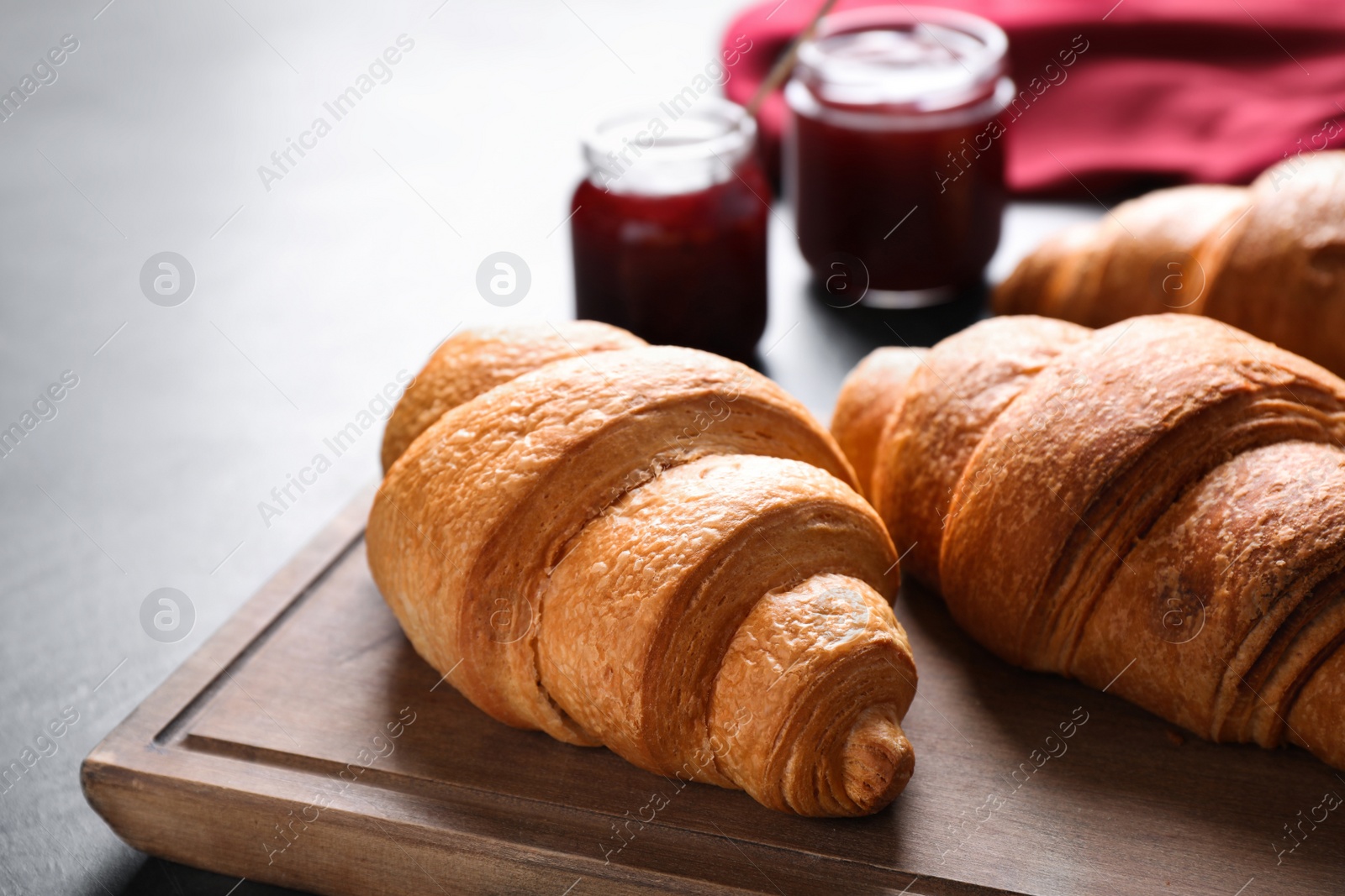 Photo of Tasty fresh croissants on grey table, closeup