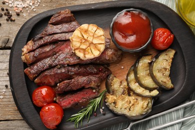 Photo of Delicious grilled beef with vegetables, tomato sauce and spices on table, top view