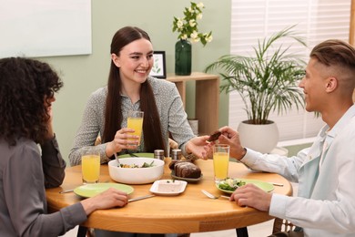 Friends having vegetarian meal at table in cafe