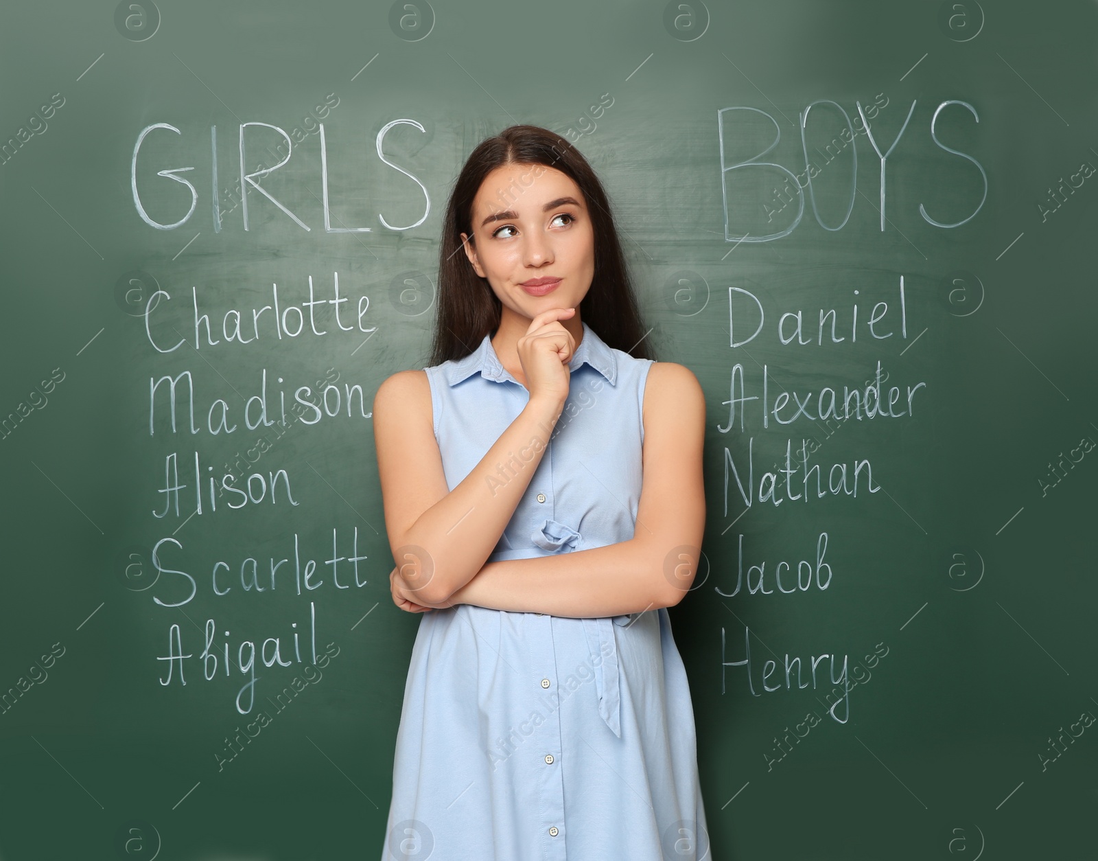 Photo of Pregnant woman near green chalkboard with different baby names