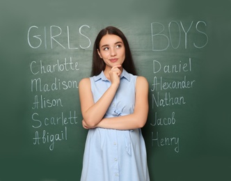 Photo of Pregnant woman near green chalkboard with different baby names