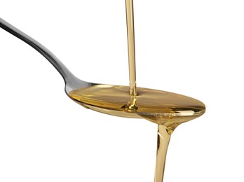 Pouring cooking oil into spoon on white background