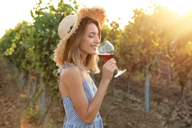 Young beautiful woman enjoying wine at vineyard