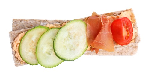 Photo of Tasty crispbreads with prosciutto, cream cheese and vegetables isolated on white, top view
