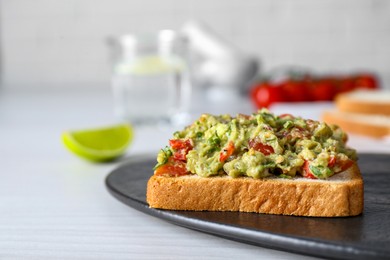 Photo of Delicious sandwich with guacamole on white table, closeup. Space for text