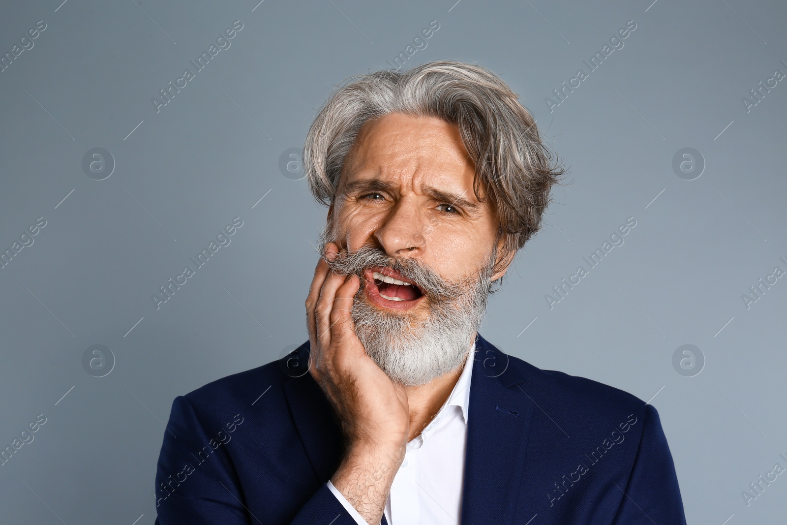 Photo of Man suffering from toothache on grey background