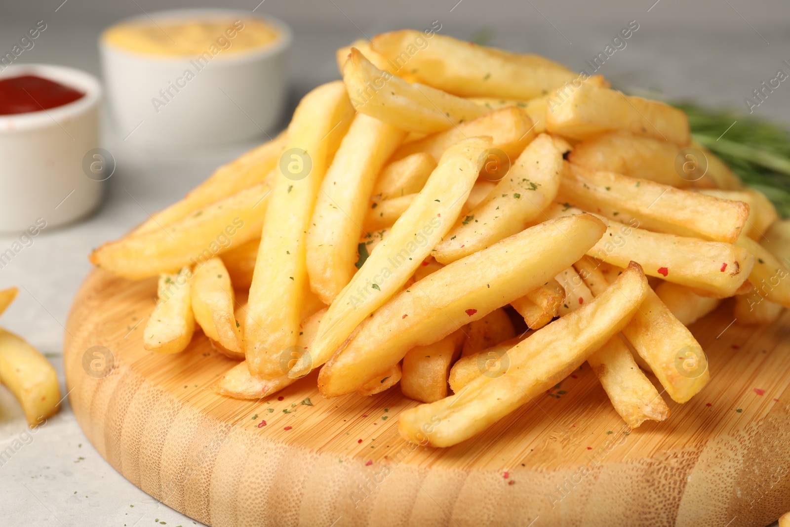 Photo of Delicious french fries on light grey marble table, closeup
