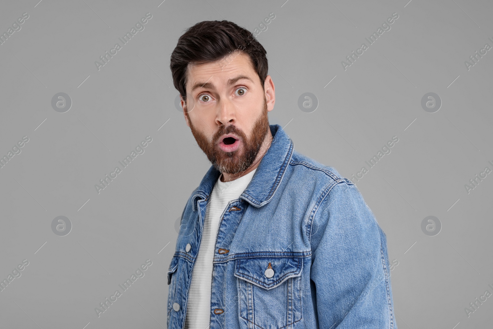 Photo of Portrait of surprised man on grey background