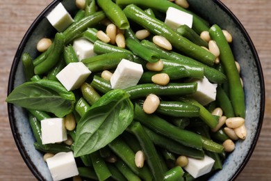 Photo of Delicious salad with green beans, pine nuts and cheese on table, top view