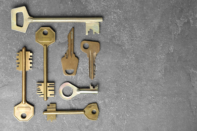 Steel keys on grey background, flat lay with space for text. Safety concept