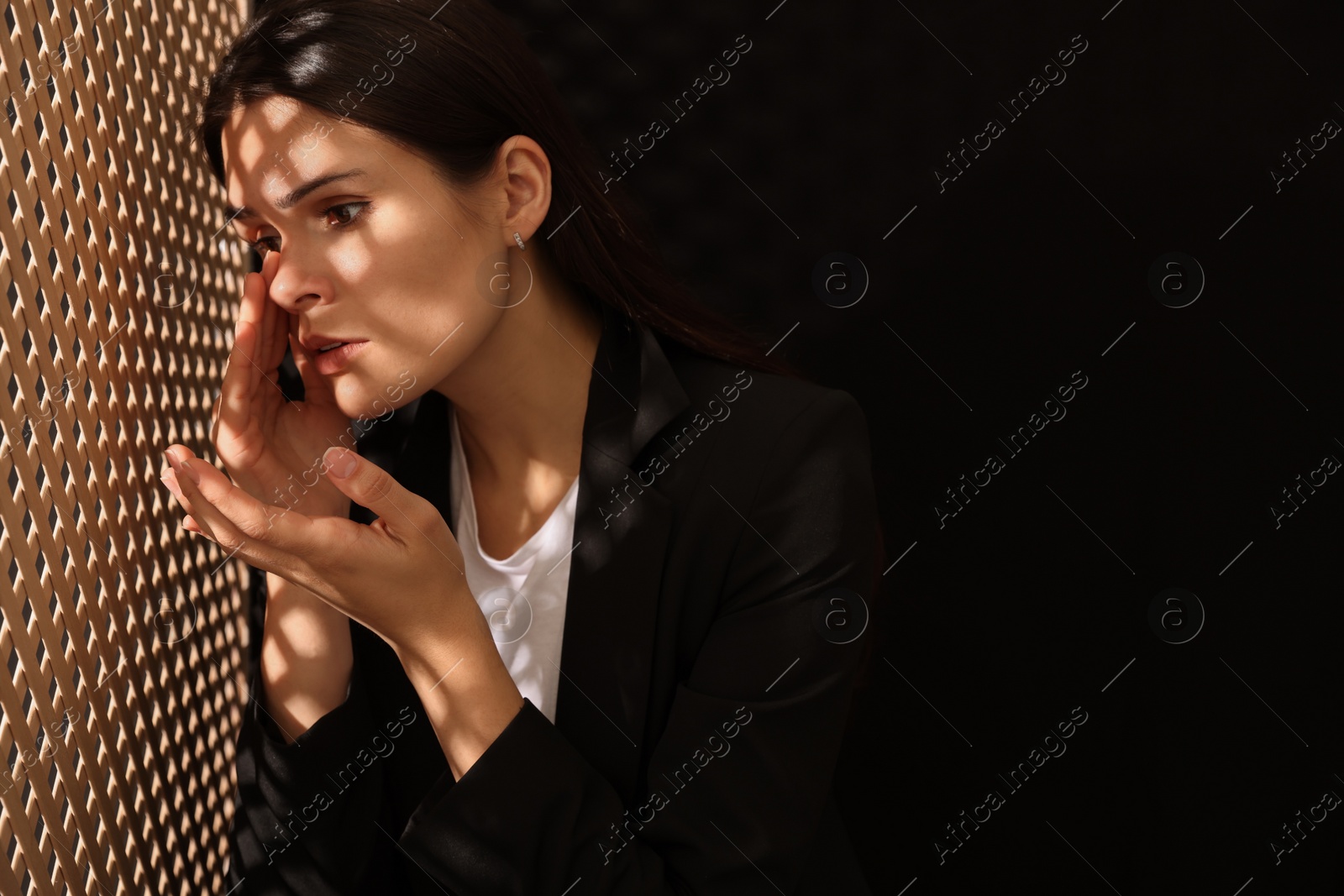 Photo of Woman talking to priest during confession near wooden partition in booth, space for text