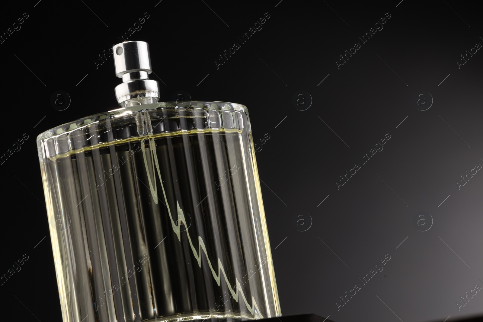 Photo of Luxury men`s perfume in bottle against grey background, space for text