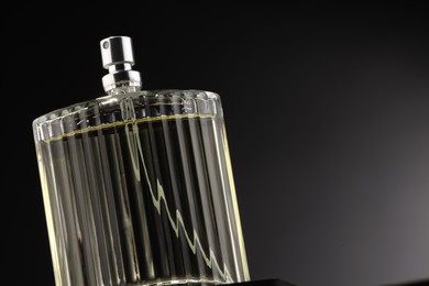 Photo of Luxury men`s perfume in bottle against grey background, space for text