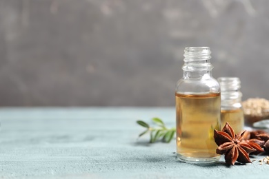 Photo of Anise essential oil and spice on light blue table, space for text