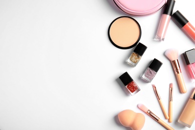 Photo of Flat lay composition with bottles of nail polish and different cosmetics on white background