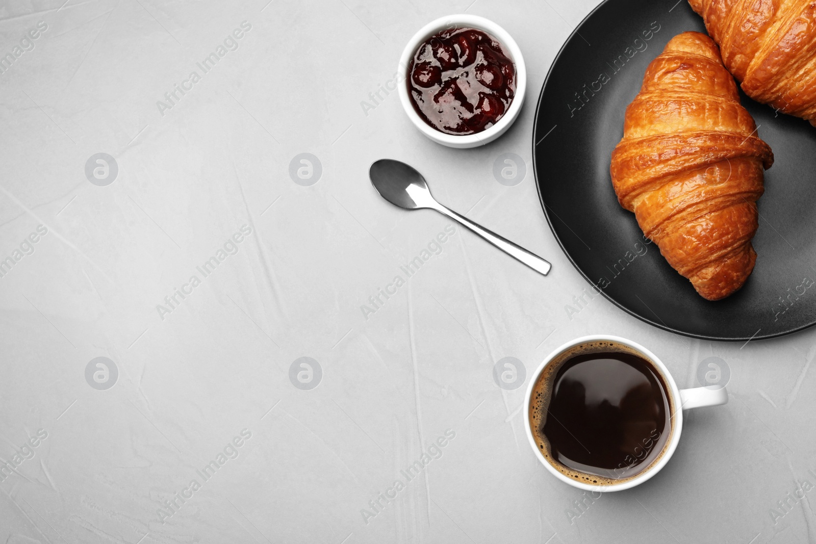 Photo of Flat lay composition with cup of coffee, jam and croissants on light background. Space for text