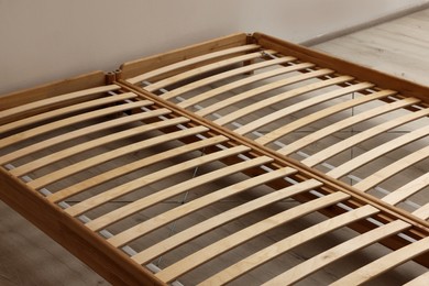 Photo of Wooden bed frame on floor in room, closeup view