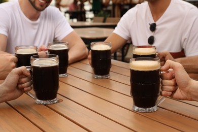Photo of Friends with glasses of beer in outdoor cafe, closeup