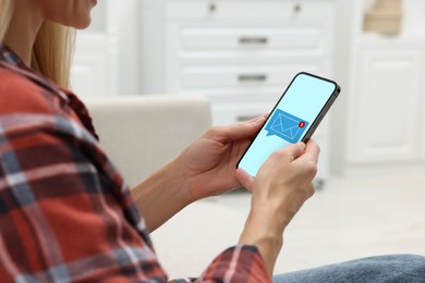 Woman received message on mobile phone indoors, closeup. Envelope illustration on device screen