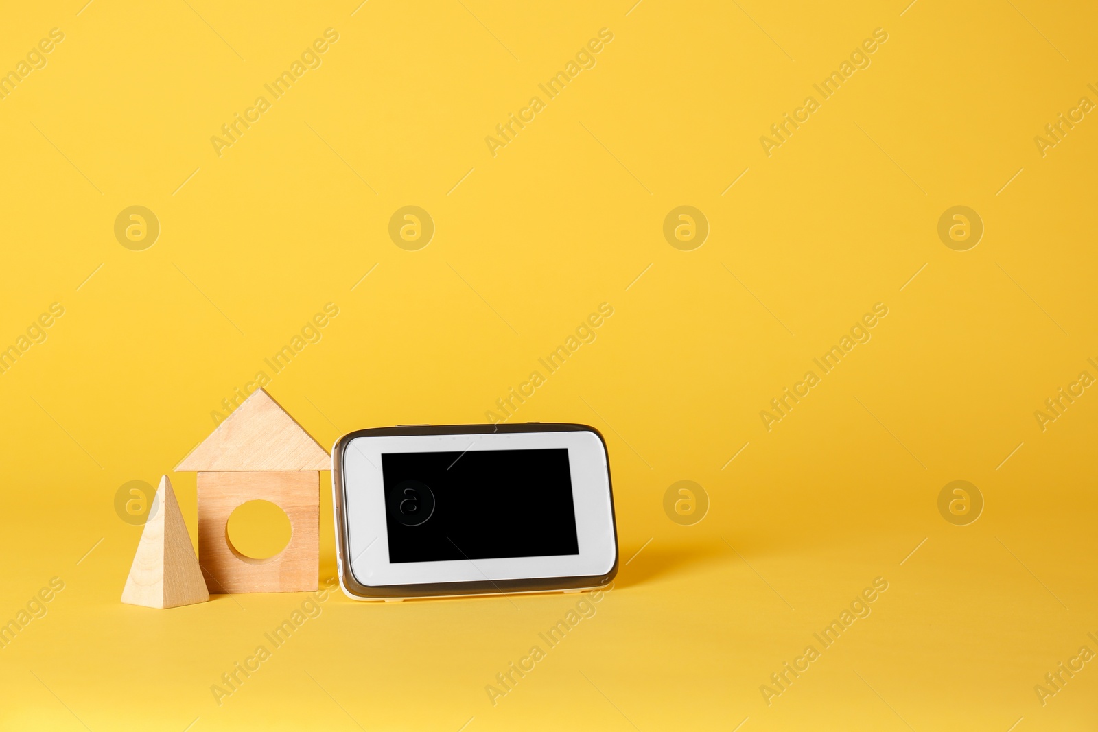 Photo of Modern monitor and wooden blocks on color background, space for text. CCTV equipment