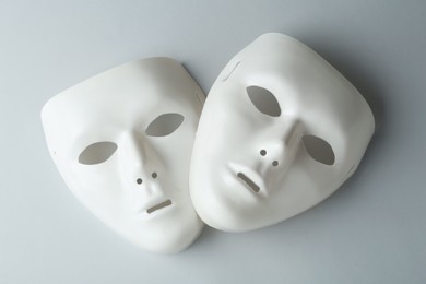 White theatre masks on grey background, flat lay