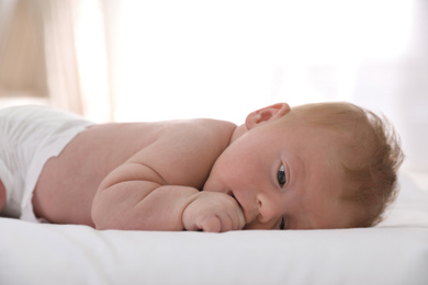 Photo of Cute little baby lying on bed at home