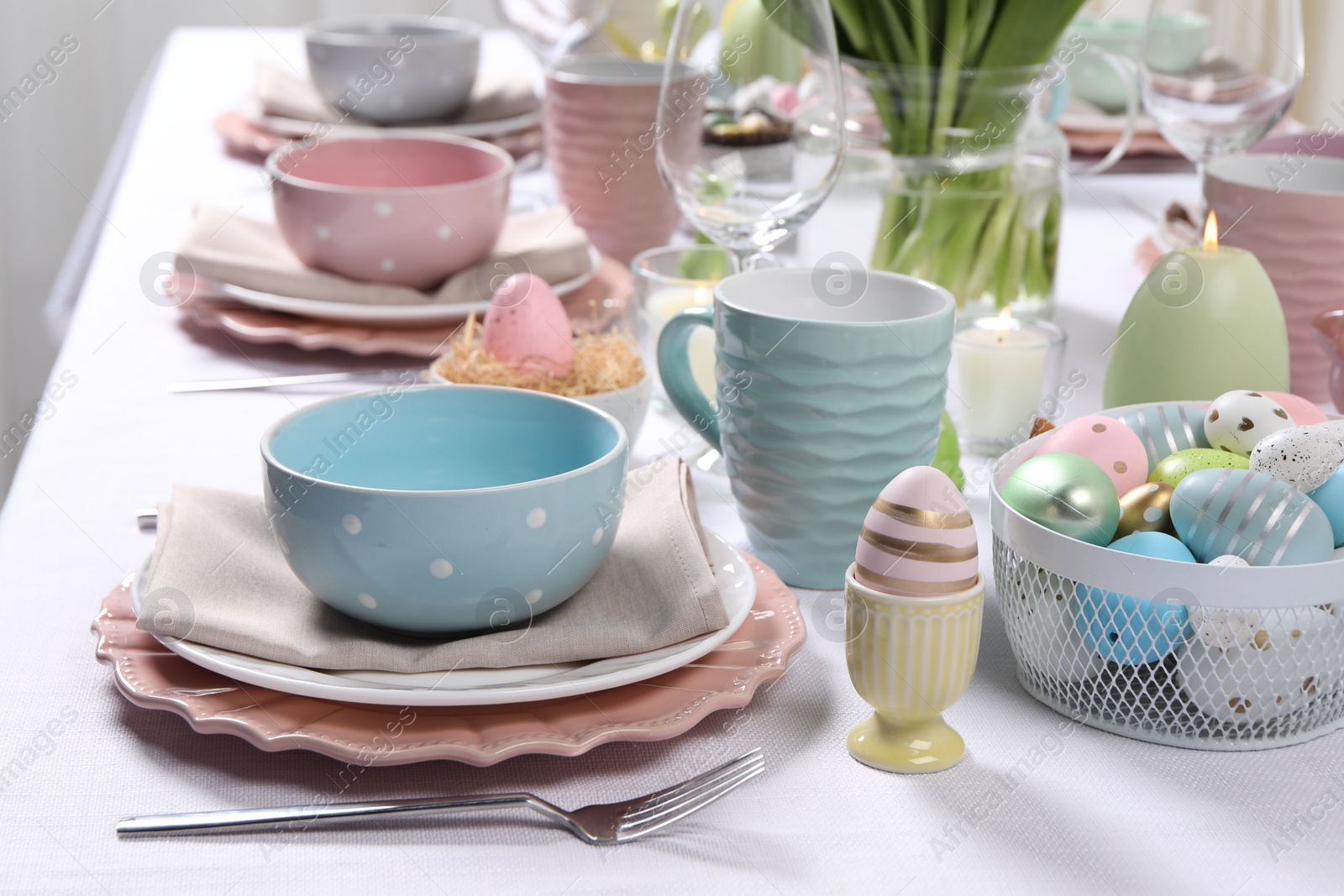 Photo of Festive table setting with painted eggs. Easter celebration