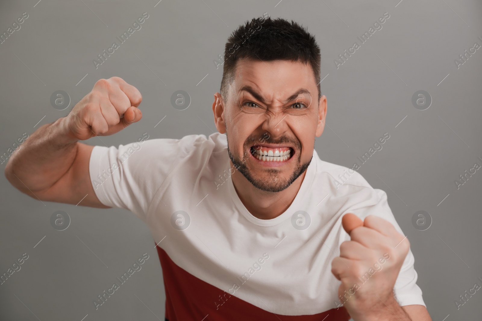 Photo of Angry man on grey background. Hate concept