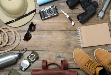 Flat lay composition with different safari accessories on wooden background, space for text