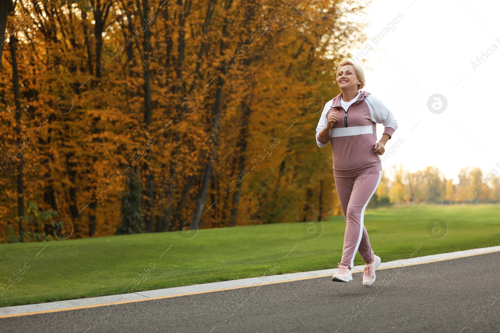 Photo of Mature woman jogging in park. Active lifestyle