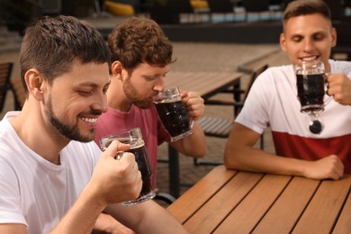 Friends with glasses of beer in outdoor cafe