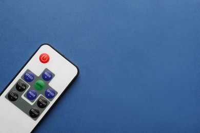 Photo of Remote control on blue background, top view. Space for text