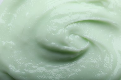 Photo of Closeup view of light green body cream as background